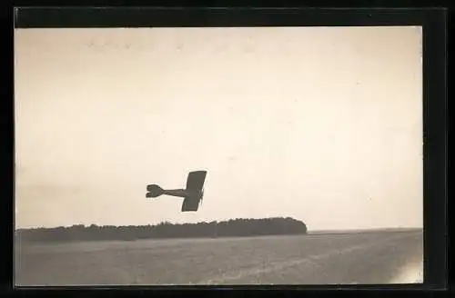 AK Ein Eindecker-Flugzeug bei einem Manöver knapp über dem Feld