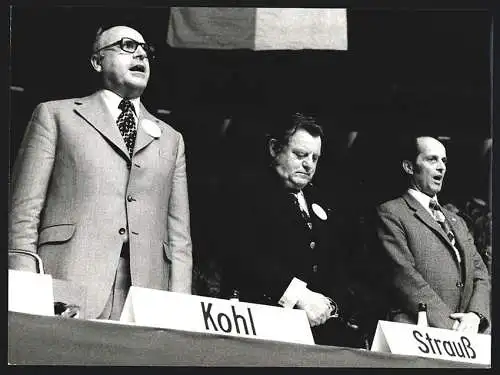 Fotografie Werek, Bonn, Helmut Kohl und Heinr. Windelen singen die Hymne, F. J. Strauss lauscht