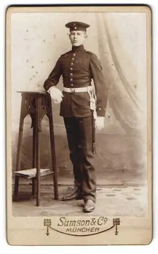 Fotografie Samson & Co., München, junger Soldat in Uniform mit Löwenkopf Faschinenmesser