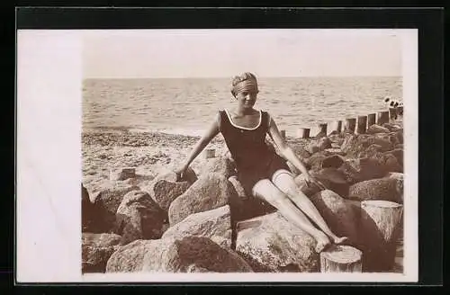 AK Dame in Bademode sitzt auf Steinen am Strand