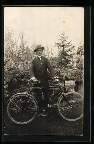 Foto-AK Junger Mann im Anzug mit seinem Fahrrad vor einer alten Mauer