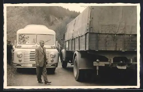 Foto-AK M.A.N. Bus und Lastkraftwagen manövrieren auf enger Strasse aneinander vorbei
