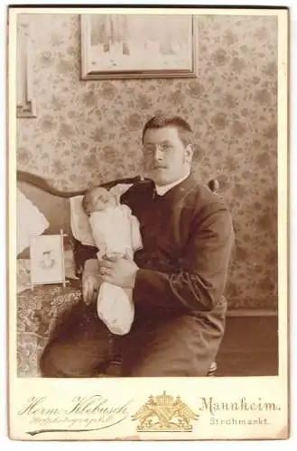 Fotografie Herm. Klebusch, Mannheim, Strohmarkt, Junger Vater mit Kneifer mit seinem Neugeborenen auf dem Arm