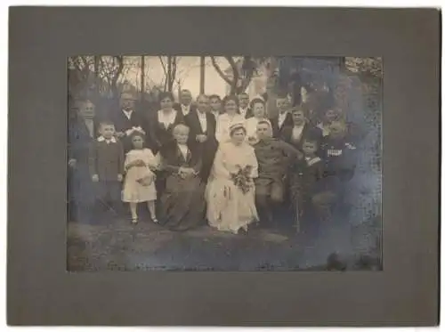 Fotografie unbekannter Fotograf und Ort, Hochzeitspaar in Feldgrau Uniform und Brautkleid, Soldat mit Ordenspang