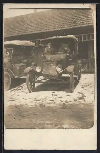 Foto-AK Auto Ford, Fahrzeug im Schnee vor einer Scheune geparkt