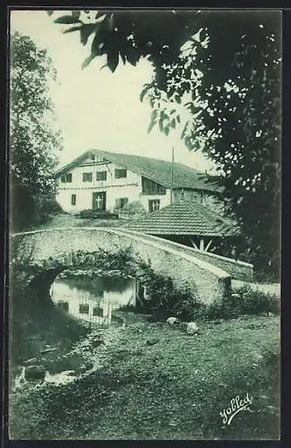 AK Cambo, une maison basque avec un pont au premier plan