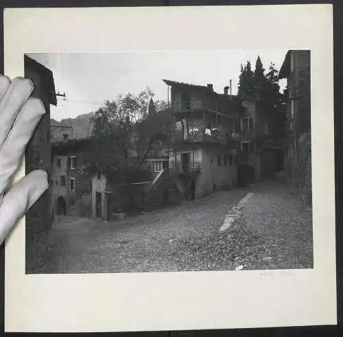 Fotografie unbekannter Fotograf, Ansicht Arco, Strassenpartie mit ärmlichen Wohnhäusern im Ort, 1960