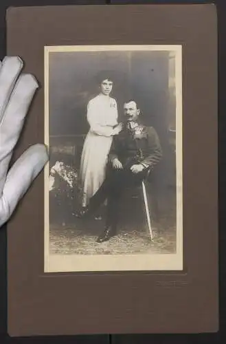 Fotografie Hch. Kölier, Pressbaum, K.u.K. Uffz. Hans in Uniform mit Ordenspange und Säbel nebst seiner Frau Berta, 1918