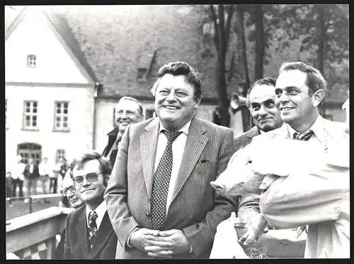 Fotografie Schubert, München, Franz Josef Strauss im gestreiften Anzug bei einer Veranstaltung neben einem Schwein