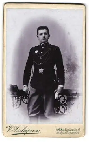 Fotografie V. Tschipani, Wien, Ennsgasse 19, K.u.K. Soldat in dunkler Uniform mit Schützenschnur und Bajonett