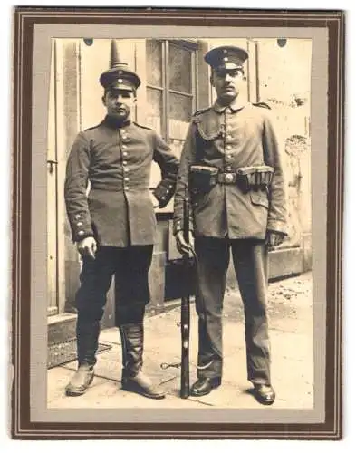 Fotografie unbekannter Fotograf und Ort, zwei Soldaten in Feldgrau Uniform mit Schützenschnur und Gewehr