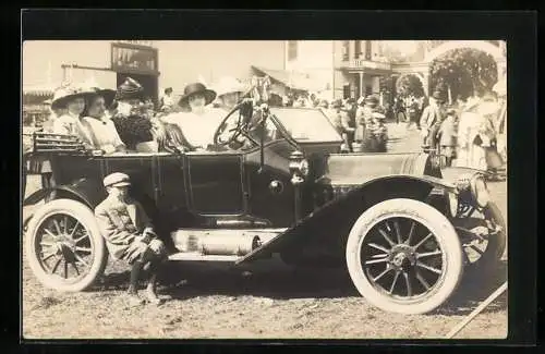 Foto-AK Auto auf der Strasse einer Ortschaft, Damen im PKW, Lnabe auf dem Trittbrett