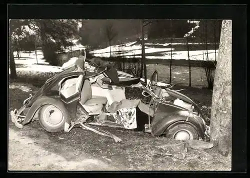 Foto-AK Auto VW Käfer, komplett zerstörtes Fahrzeug vor einem Baum nach einem Unfall