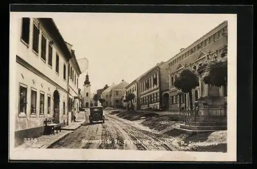 AK St. Oswald bei Freistadt, Strassenpartie mit Denkmal und Auto, Blick zur Kirche