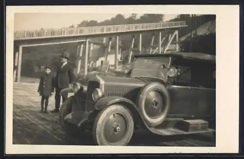 Foto-AK Auto vor einer im Bau befindlichen Brücke