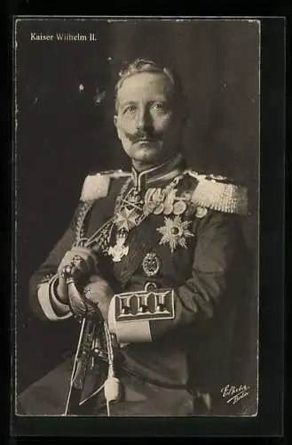 AK Kaiser Wilhelm II. mit Orden, Epauletten und Degen in der Hand, posiert auf einem Stuhl