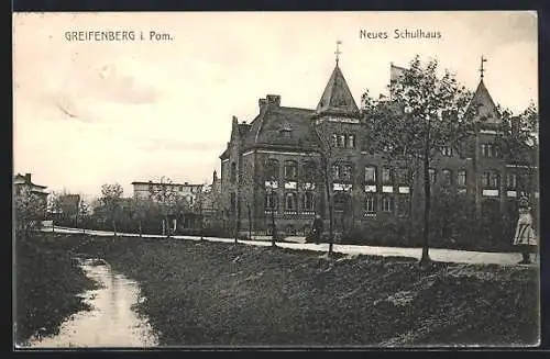 AK Greifenberg i. Pom., Neues Schulhaus mit Strasse und Gewässer