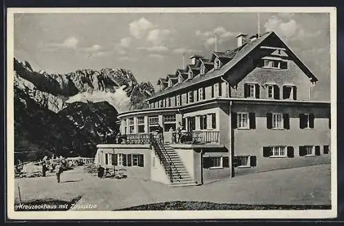 AK Kreuzeckhaus, die Berghütte mit Besuchern gegen die Zugspitze