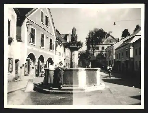 Fotografie unbekannter Fotograf, Ansicht Weyer, junge Frauen lehnen am Marktbrunnen, Geschäfte