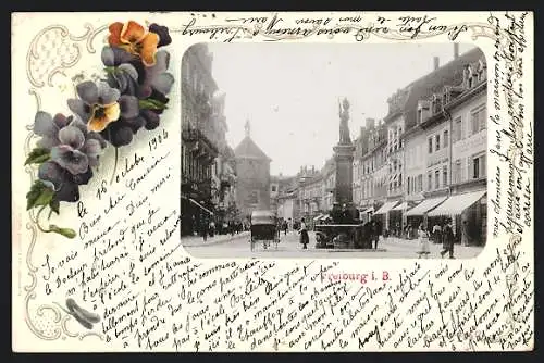 AK Freiburg i. B., Bertoldstrasse mit Denkmal, florales Passepartout