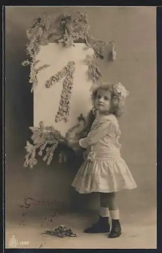 Foto-AK NPG Nr. 1587: Junges Mädchen mit Schleife im Haar an einem grossen floralen Kalenderblatt mit der 1