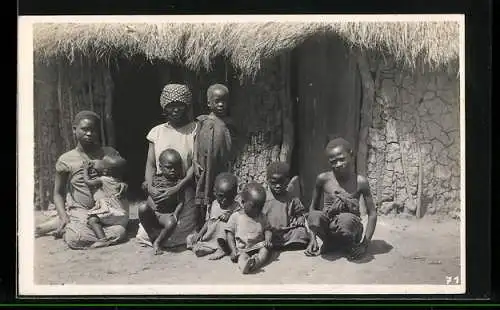 Fotografie Leopold Gabriel, Katanga, Zwei kongolesische Frauen und sieben Kinder vor einer Hütte