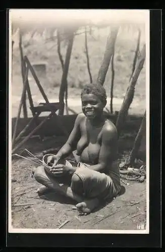 Fotografie Leopold Gabriel, Katanga, Lächelnde kongolesische Frau mit Skarifizierungen beim Flechten eines Korbes