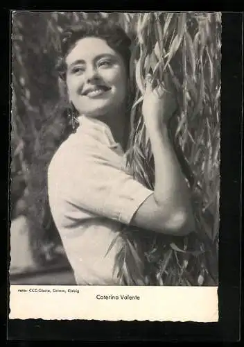 AK Schauspielerin Caterina Valente lehnt an einem Baum