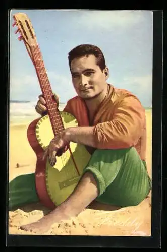 AK Musiker Freddy sitzt mit Gitarre am Strand