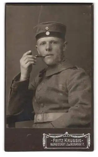 Fotografie Fritz Krussig, Burgstädt i. Sa., Neugasse 2, Porträt eines Soldaten in Uniform mit Pfeife