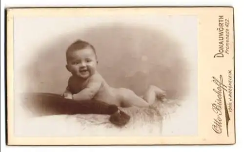 Fotografie Otto Bischoff, Donauwörth, Promenade 422, Lächelndes Baby auf dem Bauch liegend