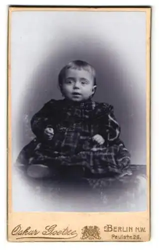 Fotografie Oskar Goetze, Berlin, Paulstr. 26, Portrait eines kleinen Kindes im karierten Kleid