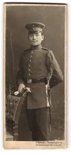 Fotografie P. Krabo, Frankfurt a. O., Wilhelmsplatz 20, Soldat in Uniform neben einem Stuhl