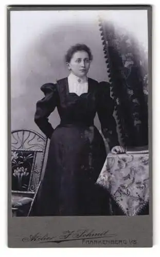 Fotografie Atelier F. Schmit, Frankenberg i. S., Frau in elegantem Kleid neben dekoriertem Tisch