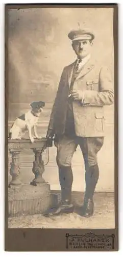 Fotografie Kulhanek, Berlin, Müllerstr. 137, Eleganter Herr in Reitbekleidung nebst Terrier, Hund auf Brüstung sitzend