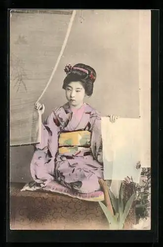 AK Sitzende junge Geisha, Portrait mit Papierbogen