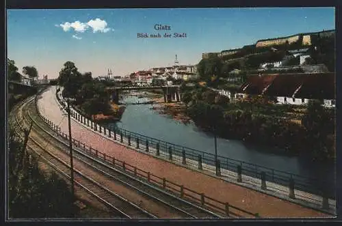 AK Glatz, Flusspartie mit Stadtblick, Bahngleisen und Uferstrasse