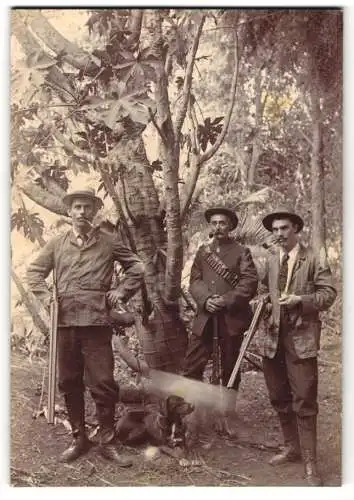 Fotografie unbekannter Fotograf und Ort, Grosswildjäger in Sansibar mit Jagdhund und Flinte / Büchse