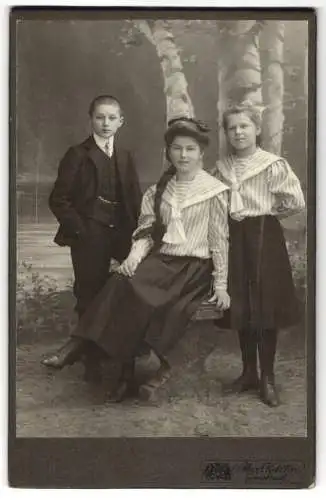 Fotografie Max Ketzler, Innsbruck, Heiliggeiststrasse 9, Brünette Frau mit langem Zopf nebst Kindern vor Kulisse