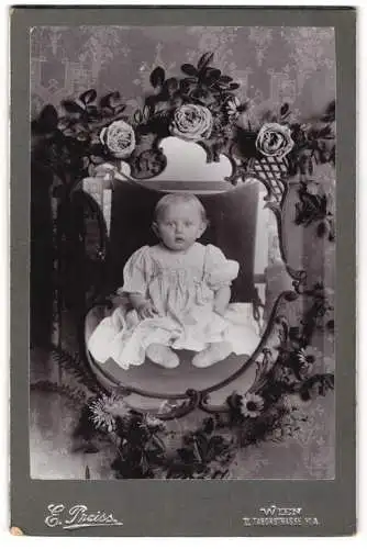 Fotografie E. Preiss, Wien, Taborstrasse 11a, Baby auf Thron sitzend im Passepartout