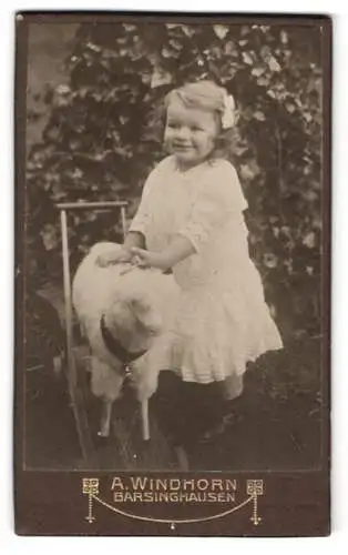 Fotografie A. Windhorn, Barsinghausen, lächelndes Mädchen mit Spielzeug-Schaf auf Rollen