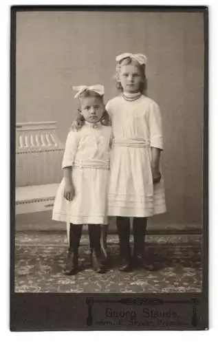 Fotografie Georg Staude, Prenzlau, Mädchen mit Haarschleife tragen das gleiche weisse Kleid