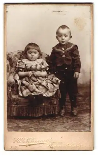 Fotografie Heinrich Schmeck, Siegen, Bahnhofstrasse 12, Zwei Kinder auf einem dekorativen Stuhl