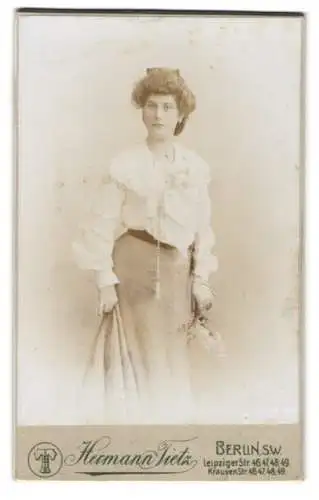 Fotografie Hermann Tietz, Berlin, Leipziger Str. 46-49, Junge Dame in eleganter Kleidung mit Blumenstrauss