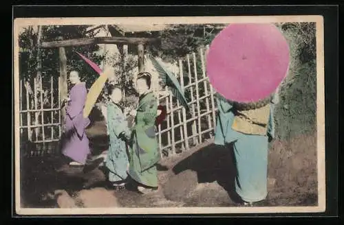 AK Junge Geishas mit Schirmen an einem Tor