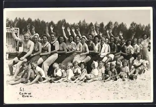 Foto-AK Grömitz, Winkende Urlauber in Bademode und ihre Kinder am Strand