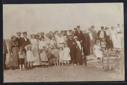 Foto-AK Grömitz, Urlauber mit Kindern posieren für ein Gruppenfoto am Strand