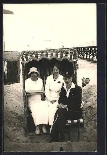 Foto-AK Grömitz, Zwei Frauen und ein Mann sitzen im Strandkorb