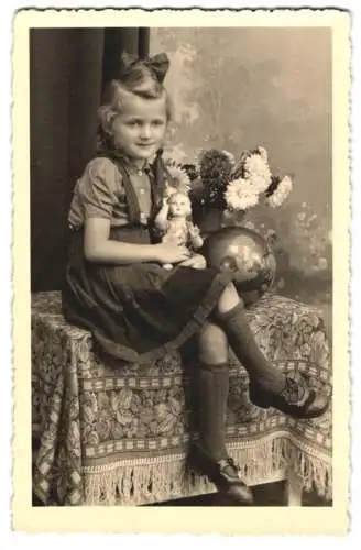 Fotografie Rudol Teich, Neustadt / Sachsen, Mädchen Helga mit Haarschleife und Puppe im Foto-Atelier