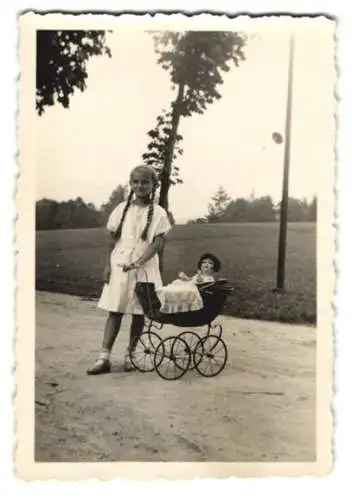 Fotografie Mädchen mit langen Zöpfen und Puppe im Puppenwagen, Doll, Dolly